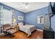Bright bedroom with hardwood floors, blue accent wall, and plush armchair at 3243 Stonegate Falls Dr, Land O Lakes, FL 34638