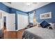 Bedroom with blue walls, hardwood floors, walk-in closet, and ceiling fan at 3243 Stonegate Falls Dr, Land O Lakes, FL 34638