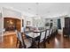 Open-concept dining area with hardwood flooring, a long table with ample seating, and elegant decor at 3243 Stonegate Falls Dr, Land O Lakes, FL 34638