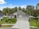 Stunning aerial view of the home features a three-car garage, mature landscaping, and a well manicured lawn at 3243 Stonegate Falls Dr, Land O Lakes, FL 34638