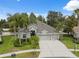 Stunning aerial view of the home features a three-car garage, mature landscaping, and a well manicured lawn at 3243 Stonegate Falls Dr, Land O Lakes, FL 34638