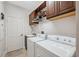 This laundry room features a sink, two cabinets, and white washer and dryer units at 3243 Stonegate Falls Dr, Land O Lakes, FL 34638