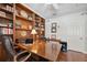 Bright home office with wood built-ins, desk, hardwood floors, and a ceiling fan at 3243 Stonegate Falls Dr, Land O Lakes, FL 34638