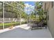 The screened-in patio offers a sunny spot for relaxing on lounge chairs with views of the backyard at 3243 Stonegate Falls Dr, Land O Lakes, FL 34638