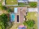 Aerial view of a home with a screened pool, solar panels, and well-maintained landscaping at 3468 El Prado Ave, Spring Hill, FL 34609