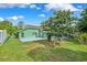 Spacious backyard featuring mature landscaping, an enclosed pool area, and patio at 3468 El Prado Ave, Spring Hill, FL 34609