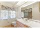 Bright bathroom featuring floral window coverings and a large vanity area with sink and updated fixtures at 3468 El Prado Ave, Spring Hill, FL 34609