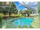 Sparkling in-ground pool enclosed in a screen for outdoor enjoyment with tiled trim at 3468 El Prado Ave, Spring Hill, FL 34609
