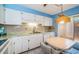 Bright and functional kitchen featuring white cabinets, modern appliances, and a cozy dining area at 3838 Lanyard Ct # B, New Port Richey, FL 34652