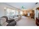 Inviting living room with neutral carpet, bright windows, a ceiling fan and a dining area at 3838 Lanyard Ct # B, New Port Richey, FL 34652