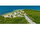Aerial view of a park with sandy beach, palm trees, covered picnic areas, and the blue waters of the Gulf of Mexico at 4025 Stratfield Dr, New Port Richey, FL 34652