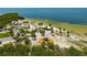 Aerial view of a park featuring a playground, beach, picnic area, and palm trees, overlooking the water at 4025 Stratfield Dr, New Port Richey, FL 34652