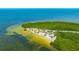 Overhead view of a beautiful park featuring a sandy beach area with picnic shelters, palm trees, and clear blue waters at 4025 Stratfield Dr, New Port Richey, FL 34652