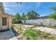 Backyard featuring a modern white fence, side entry door and minimal greenery at 4025 Stratfield Dr, New Port Richey, FL 34652