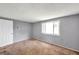 This carpeted bedroom has a window to bring in natural light and a white door at 4025 Stratfield Dr, New Port Richey, FL 34652