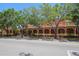 Exterior view of a brick building featuring a colonnade and mature trees at 4025 Stratfield Dr, New Port Richey, FL 34652
