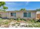 Tan stucco home featuring bright, natural light through two windows, surrounded by minimal landscaping at 4025 Stratfield Dr, New Port Richey, FL 34652
