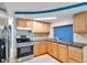 Close up of a kitchen featuring wooden cabinets, stainless steel appliances, and tiled floors at 4025 Stratfield Dr, New Port Richey, FL 34652