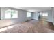 Bright living room with light-blue walls, carpet, and a window offers ample sunlight at 4025 Stratfield Dr, New Port Richey, FL 34652