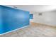 Spacious living area with tile floors, and a bright blue accent wall adjacent to other rooms at 4025 Stratfield Dr, New Port Richey, FL 34652
