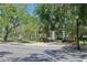 A shady city park with seating, flowers, and mature trees across the street with crosswalk at 4025 Stratfield Dr, New Port Richey, FL 34652