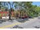 A charming street view of a brick building under a canopy of mature trees and two cars parked along the road at 4025 Stratfield Dr, New Port Richey, FL 34652