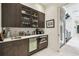 Modern bar area with dark wood cabinetry, wine refrigerator, and stainless steel appliances at 4333 Harborpointe Dr, Port Richey, FL 34668