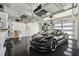 A modern garage features a sleek black sports car parked inside, complemented by overhead storage and clean design at 4333 Harborpointe Dr, Port Richey, FL 34668