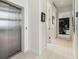 Bright hallway with modern elevator access and view into a home office at 4333 Harborpointe Dr, Port Richey, FL 34668