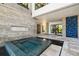 A modern hot tub with mosaic tiles is framed by sleek stone work and decorative art at 4333 Harborpointe Dr, Port Richey, FL 34668