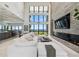Bright living room with high ceilings, a stone accent wall, and expansive windows overlooking the ocean at 4333 Harborpointe Dr, Port Richey, FL 34668