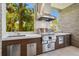 An outdoor kitchen with stainless steel appliances and stone accents blends functionality with upscale design at 4333 Harborpointe Dr, Port Richey, FL 34668
