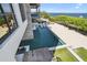 A luxurious pool area extends to a private sandy beach, overlooking the water, framed by modern architecture at 4333 Harborpointe Dr, Port Richey, FL 34668