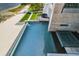 Aerial perspective of a large pool featuring a hot tub, adjacent to a sandy beach and contemporary home at 4333 Harborpointe Dr, Port Richey, FL 34668