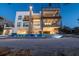 Modern home's rear exterior with multiple balconies overlooking an ocean view, sandy yard, and beach access at 4333 Harborpointe Dr, Port Richey, FL 34668