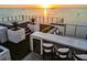 Chic rooftop bar featuring bar seating, a mini fridge, and open ocean views at sunset at 4333 Harborpointe Dr, Port Richey, FL 34668