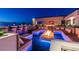 Rooftop deck featuring a fire pit, bar, and lounge seating with ocean views at dusk at 4333 Harborpointe Dr, Port Richey, FL 34668