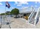 Waterfront home with a paved patio, comfortable seating, and a staircase leading to a second story deck at 4387 6Th Isle Dr, Hernando Beach, FL 34607
