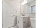 Bathroom featuring marble tile, a white vanity with modern fixtures, and a door to the left of the vanity at 4482 Kingston Dr, Hernando Beach, FL 34607
