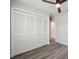 Bedroom featuring wood-look flooring, a ceiling fan, a white closet, and a white door to another room at 4482 Kingston Dr, Hernando Beach, FL 34607