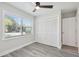Bedroom with wood-look flooring, a ceiling fan, closet, and a large window with a view of the neighborhood at 4482 Kingston Dr, Hernando Beach, FL 34607