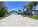 Beautiful aqua home with a paver driveway and meticulously maintained landscaping under a blue sky at 4482 Kingston Dr, Hernando Beach, FL 34607