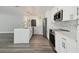 Updated kitchen with white cabinets, gray backsplash, a quartz island, and stainless steel appliances at 4482 Kingston Dr, Hernando Beach, FL 34607