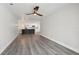 Open-concept living space with sleek wood floors, a modern ceiling fan, and a view into the kitchen at 4482 Kingston Dr, Hernando Beach, FL 34607