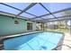 Relaxing screened pool with clear blue water, surrounded by pavers and a tranquil setting at 4482 Kingston Dr, Hernando Beach, FL 34607