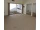 Open-concept living room with plush carpet and sliding glass doors leading to an outdoor area at 4529 Keelboat Pl, New Port Richey, FL 34652