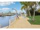 Backyard with a canal view and boat lift; includes a manicured lawn and waterfront seating at 4942 Blue Heron Dr, New Port Richey, FL 34652