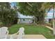Lush backyard featuring a charming cottage, wooden deck, and beautiful mature trees at 4942 Blue Heron Dr, New Port Richey, FL 34652