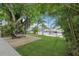 Relaxing backyard retreat with wooden deck, lounge chairs, lush greenery and waterfront views at 4942 Blue Heron Dr, New Port Richey, FL 34652