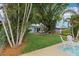 Charming home featuring a lush backyard with tropical plants and outdoor seating area at 4942 Blue Heron Dr, New Port Richey, FL 34652